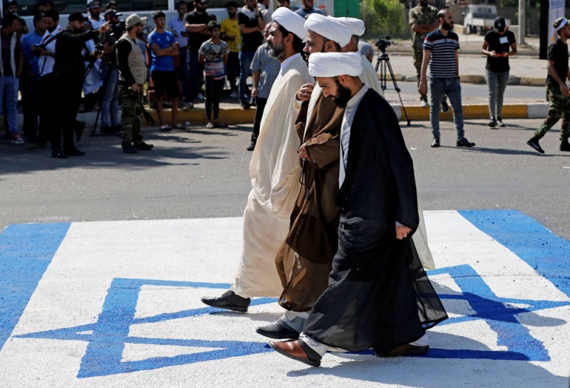 معممين من الميليشيات يمشون على علم أسرائيل