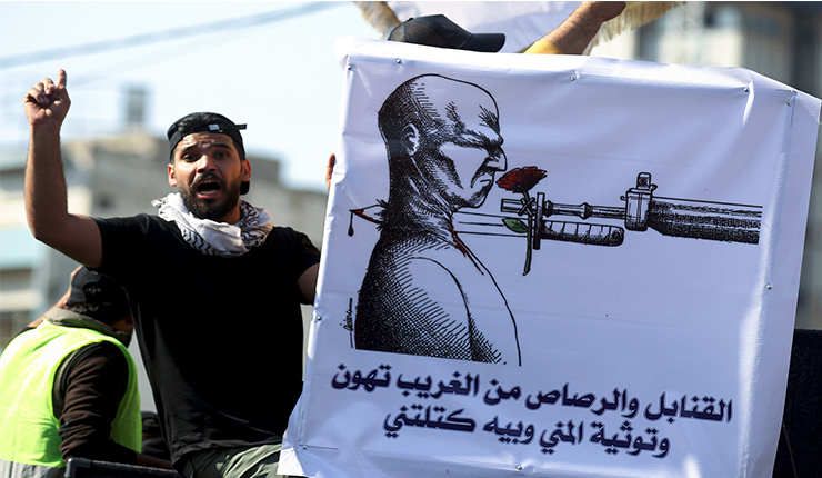 متظاهر عراقي يعرض صورة كيفية قتلهم
