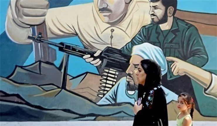 إيرانية تمر بجانب جدارية في طهران
