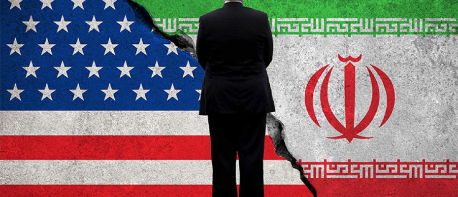 ترامب واقف أمام العلم الأمريكي والإيراني