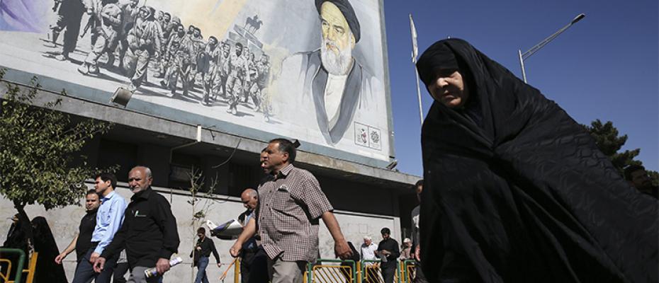 مواطنون تحت جدارية ثورية في إيران