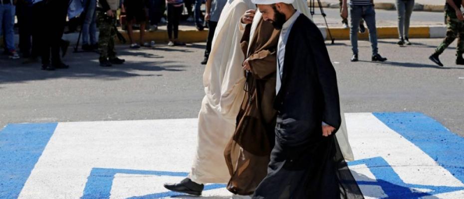 معممين من الميليشيات يمشون على علم أسرائيل